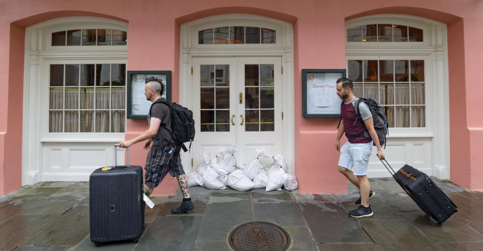 People walk past Brennan's restaurant in the French Quarter with sandbags on the front door as bands of rain from Tropical Storm Barry from the Gulf of Mexico move into New Orleans, La., Friday, July 12, 2019. (Photo: Matthew Hinton/AP)