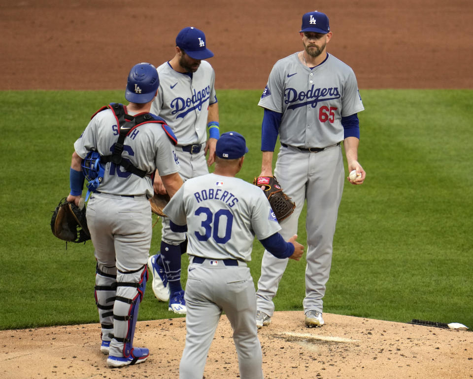 Los Angeles Dodgers starting pitcher James Paxton (65) waits to hand the ball to manager Dave Roberts (30) during the second inning of the team's baseball game against the Pittsburgh Pirates in Pittsburgh, Wednesday, June 5, 2024. (AP Photo/Gene J. Puskar)