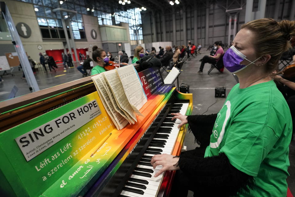 Pianist and CUNY music professor Barbara Podgurski plays with a string quartet for people who had received a COVID-19 vaccination and were waiting during the observation period, at the Jacob K. Javits Convention Center, Thursday, March 18, 2021, in New York. The convention center, which early in the pandemic served as a temporary field hospital, has been converted into a massive vaccination site. (AP Photo/Kathy Willens)