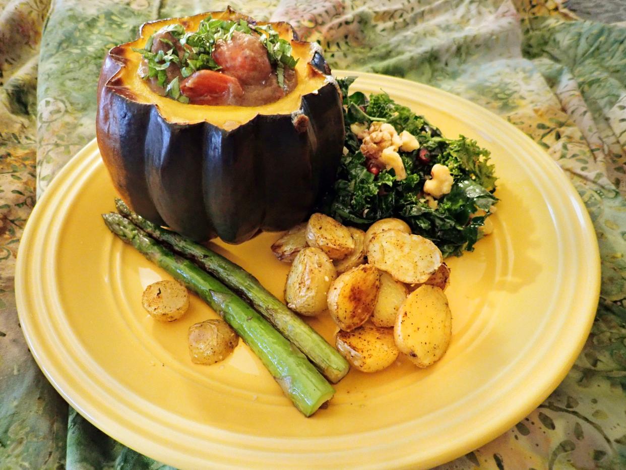 Black Bean Soup Served in an Acorn Squash Bowl is a holiday celebration of flavors, texture and colors. Here it is plated with pan-seared asparagus, kale salad with pomegranate seeds and walnuts, and roasted peewee potatoes.