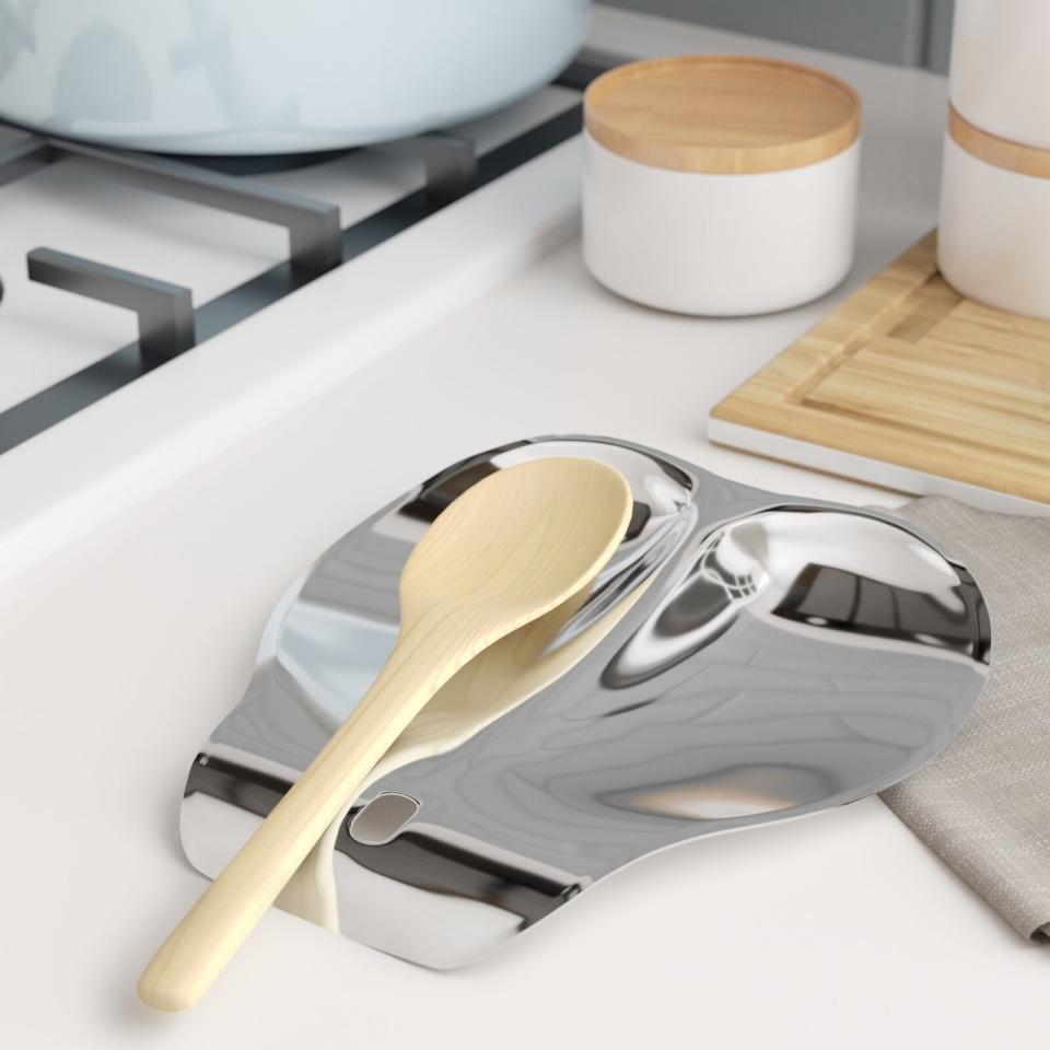 A wooden spoon resting in a metal spoon rest.