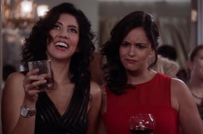 Rosa Diaz has her head thrown back as she laughs while Amy Santiago has her eyebrows furrowed in confusion