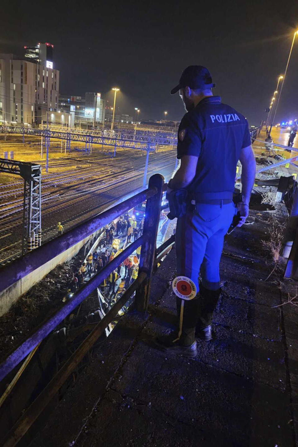 In this image made available by Italian State Police, Italian state police agents attend the scene of a passenger bus accident near the city of Venice, Italy, that fell from an elevated road, late Tuesday, Oct. 3, 2023, killing at least 21 people near the northern city of Venice. The Venice prefect said that 15 passengers survived. (Italian State Police via AP)