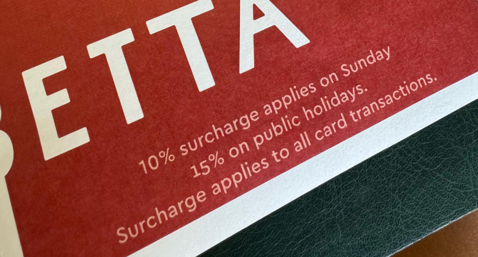 The words '10 per cent surcharge applies on Sunday' on a red menu. 