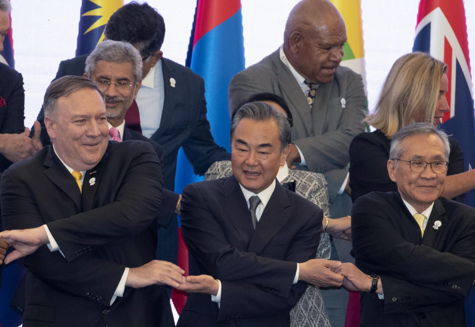 FILE - In this Aug. 2,2019, file photo, U.S. Secretary of State Mike Pompeo, left, China's Foreign Minister Wang Yi, center, and Thailand's Foreign Minister Don Pramudwinai cross their arms during the Association of Southeast Asian Nations Regional Forum in Bangkok, Thailand. Wang says Beijing will not let anyone block its right to development, including in the South China Sea, which China claims virtually in its entirety. (AP Photo/Gemunu Amarasinghe, File)