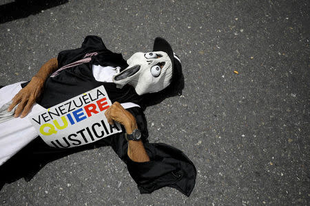 A demonstrator holds a banner that reads "VENEZUELA WANTS JUSTICE" during a rally called by health care workers and opposition activists against Venezuela's President Nicolas Maduro in Caracas, Venezuela May 22, 2017. REUTERS/Carlos Barria