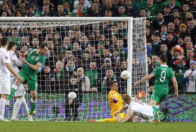 Ireland's striker Shane Long (R) scores their late equalizer past Poland's goalkeeper Lukasz Fabianski (3-R) during the Euro 2016 qualifying football match in Dublin on March 29, 2015