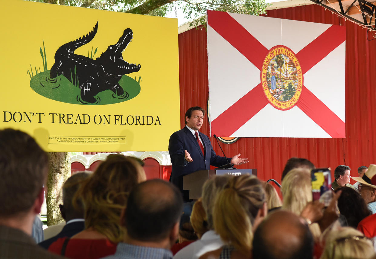 Gov. Ron DeSantis speaks to supporters from a podium, with a state flag in the background along with a large sign that reads: Don't tread on Florida.