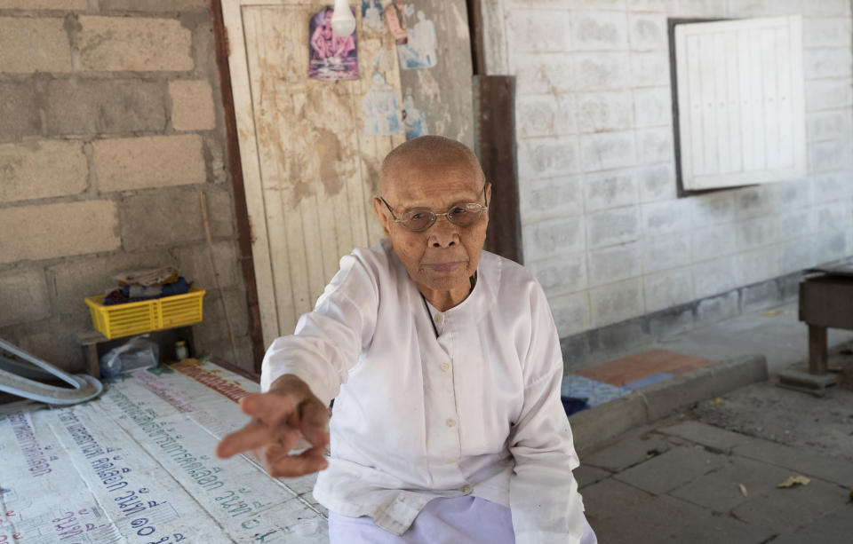 Buddhist nun Samrit Kuimeunwai, 85 year old, recalls details during an interview at the scene of the weekend's mass shooting that partially took place at the Wat Pa Sattharuam temple, Tuesday, Feb. 11, 2020, in Nakhon Ratchasima, Thailand. A rogue Thai soldier whose rampage left 29 people dead and dozens more injured terrorized a Buddhist temple complex in rural northeastern Nakhon Ratchasima province on his way to a shopping mall, where he held shoppers hostage in a nearly 16-hour siege. (AP Photo/Sakchai Lalit)