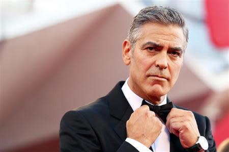 U.S. actor George Clooney adjusts his bowtie as he arrives on the red carpet for the premiere of "Gravity" at the 70th Venice Film Festival in Venice August 28, 2013. REUTERS/Alessandro Bianchi