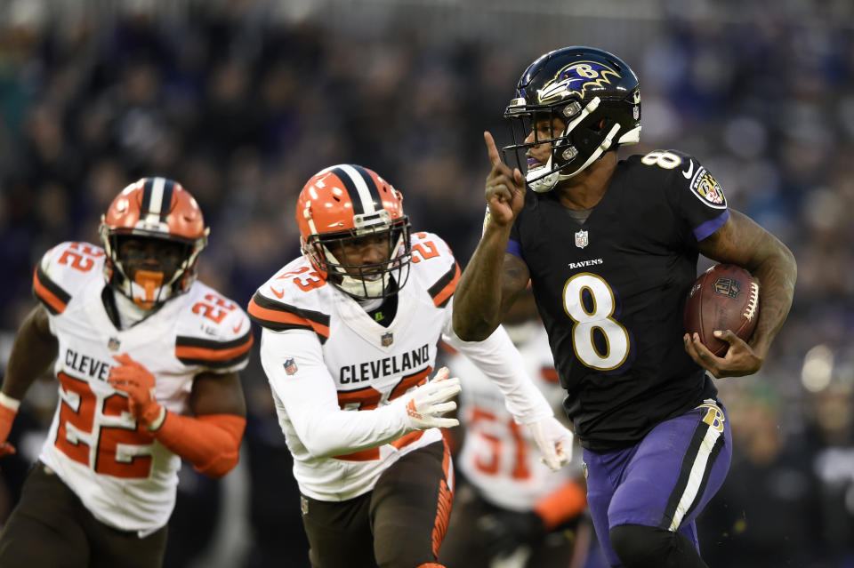 Baltimore Ravens quarterback Lamar Jackson, right, rushes for a touchdown past Cleveland Browns free safety Jabrill Peppers, back left, and strong safety Damarious Randall in the first half of an NFL football game, Sunday, Dec. 30, 2018, in Baltimore. (AP Photo/Gail Burton)