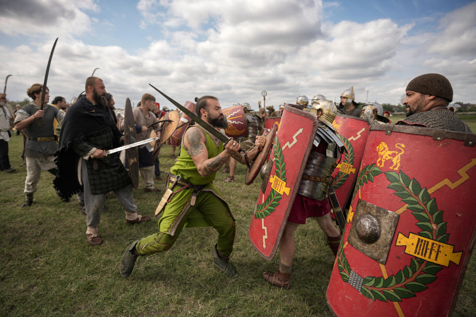 Participants in the Romula Fest historic reenactment event clash during a battle in the village of Resca, Romania, Sunday, Sept. 4, 2022. (AP Photo/Andreea Alexandru)