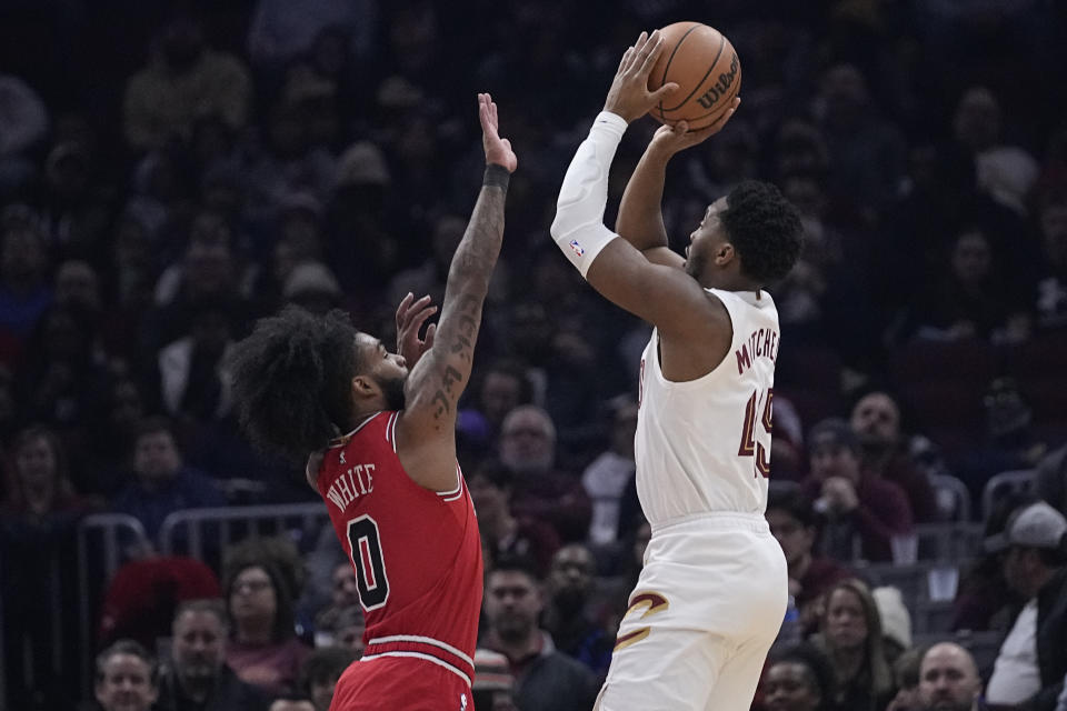 Cleveland Cavaliers guard Donovan Mitchell, right, looks to shoot as Chicago Bulls guard Coby White (0) defends in the first half of an NBA basketball game, Monday, Jan. 15, 2024, in Cleveland. (AP Photo/Sue Ogrocki)