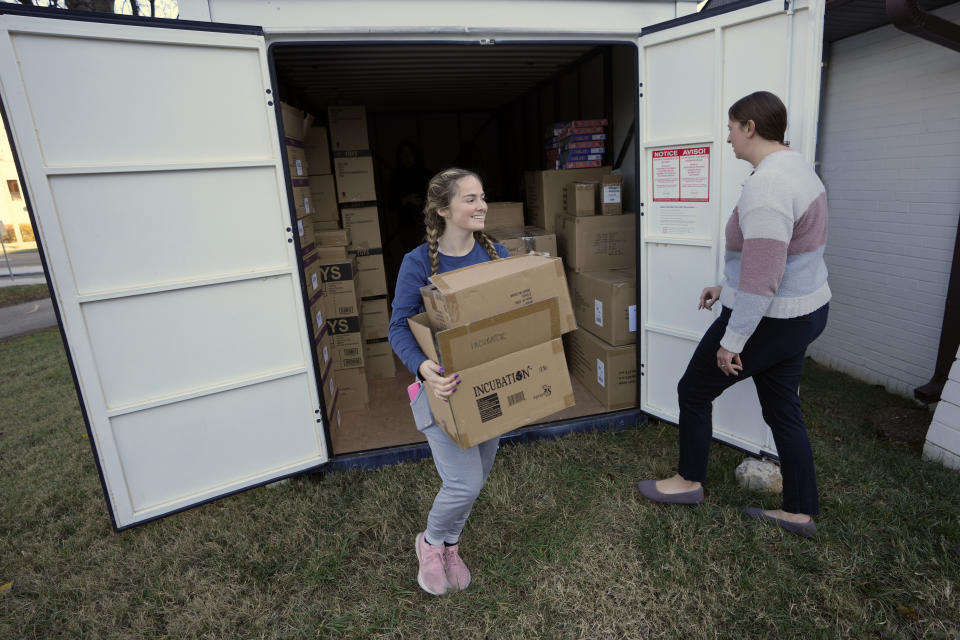 Molly Armbrecht, left, and Brittany Tolbert get boxes of toys from a storage shed at The Toy Store, a free-referral based toy store Thursday, Dec. 7, 2023, in Nashville, Tenn. The facility is co-founded by Brad Paisley and Kimberly Williams-Paisley. The couple also started The Store, a free-referral based grocery store they opened in partnership with Belmont University in March 2020. (AP Photo/Mark Humphrey)
