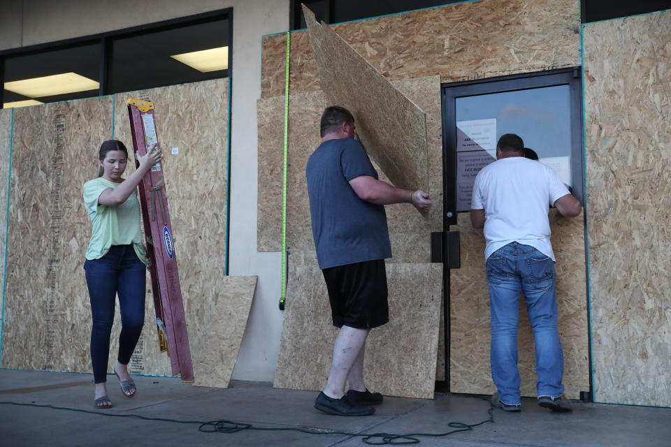 (L-R) Lacey Buller, Tyler Arnold, and Mike Buller work on placing plywood over the windows of their business before the arrival of Hurricane Laura on August 25, 2020, in Lake Charles, Louisiana. (Photo by Joe Raedle/Getty Images)