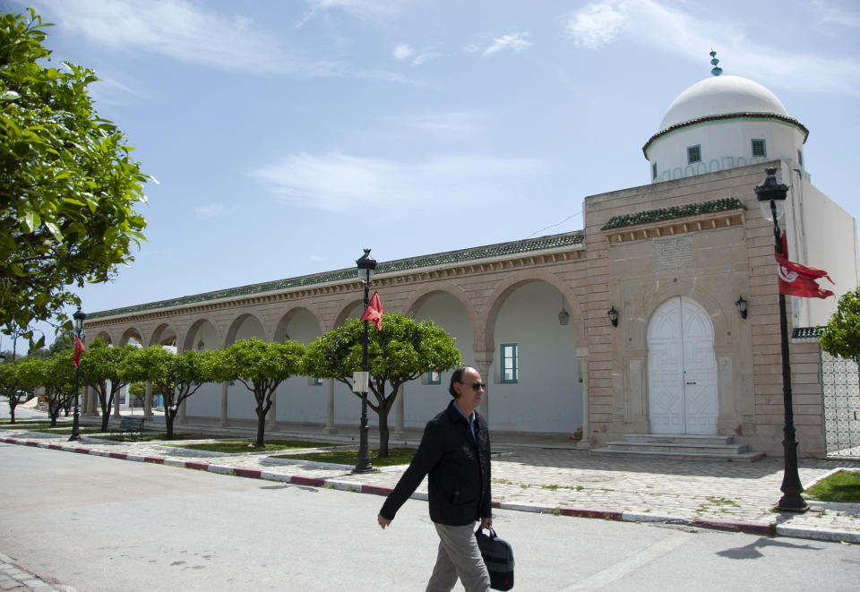 A man walks past a closed mosque in La Marsa district,just outside Tunis, Monday, May, 10, 2021. Tunisia announced on Friday strict new measures to try to contain the spread of the coronavirus, with the prime minister saying that the health system risks collapsing if something is not done. Houses of prayer are being ordered closed starting Sunday for a week, along with outdoor markets and large stores and malls. Shops selling food can remain open. (AP Photo/Hassene Dridi)