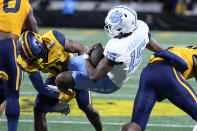 North Carolina quarterback Conner Harrell is tackled by West Virginia cornerback Beanie Bishop Jr. during the first half of an NCAA college football game at the Duke's Mayo Bowl Wednesday, Dec. 27, 2023, in Charlotte, N.C. (AP Photo/Chris Carlson)