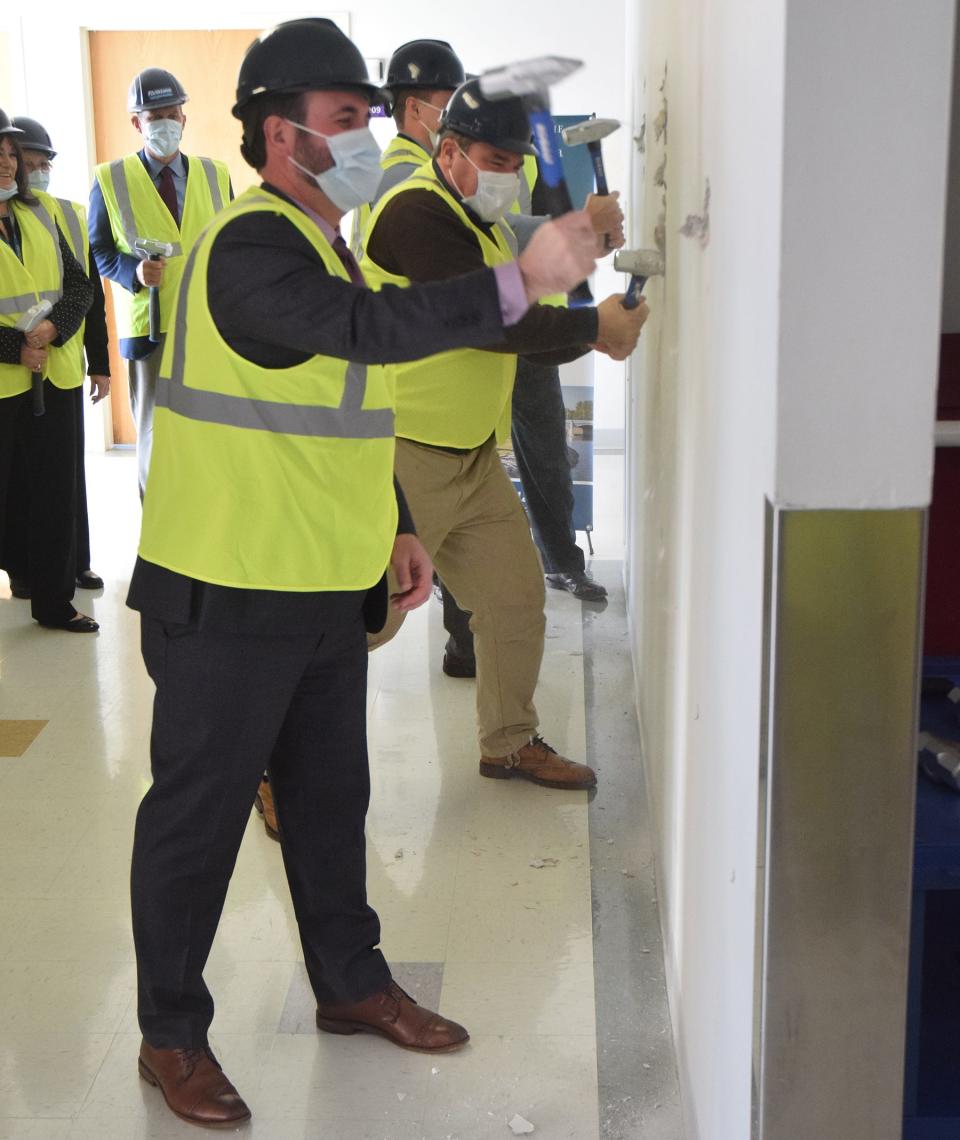 McLaren Northern Michigan president and CEO Todd Burch (front) and Michigan State Rep. John Damoose of Harbor Springs (right) knock down a wall as construction began Monday to build an inpatient behavioral health unit and partial hospitalization program at the Cheboygan Campus.