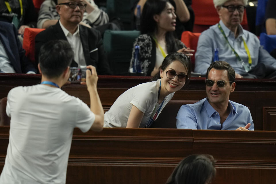 A woman gets a photo taken with retired tennis player Roger Federer during the men's singles final match between Andrey Rublev of Russia and Hubert Hurkacz of Poland in the Shanghai Masters tennis tournament at Qizhong Forest Sports City Tennis Center in Shanghai, China, Sunday, Oct. 15, 2023. (AP Photo/Andy Wong)