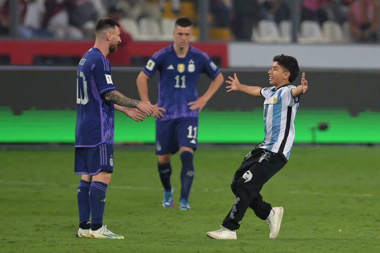 Lionel Messi recibe cariñosamente el afecto de un pequeño hincha peruano (Photo by ERNESTO BENAVIDES / AFP)