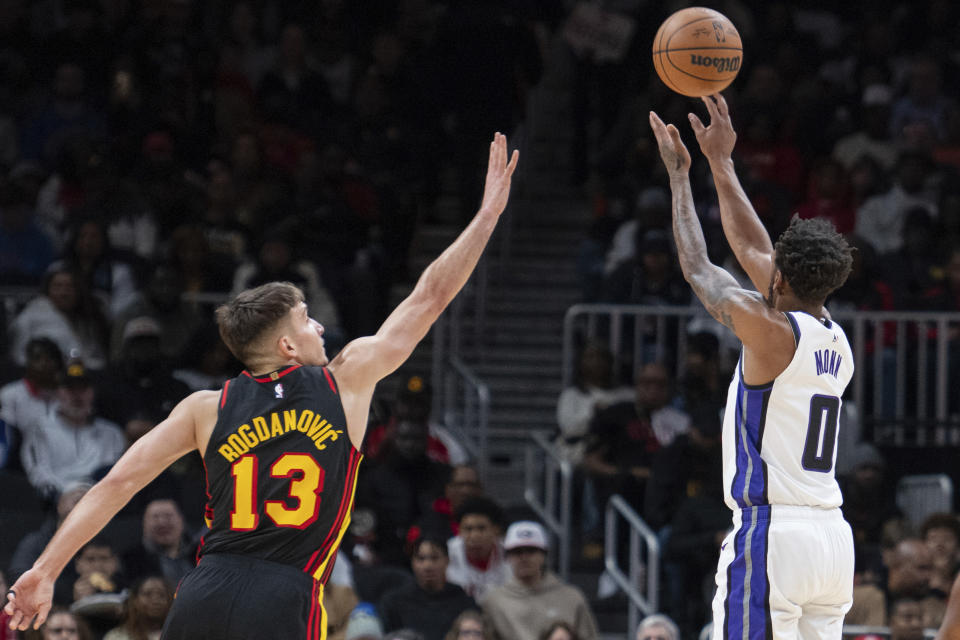 Sacramento Kings guard Malik Monk (0) shoots against Atlanta Hawks guard Bogdan Bogdanovic (13) during the first half of an NBA basketball game Friday, Dec 29, 2023, in Atlanta. (AP Photo/Hakim Wright Sr.)