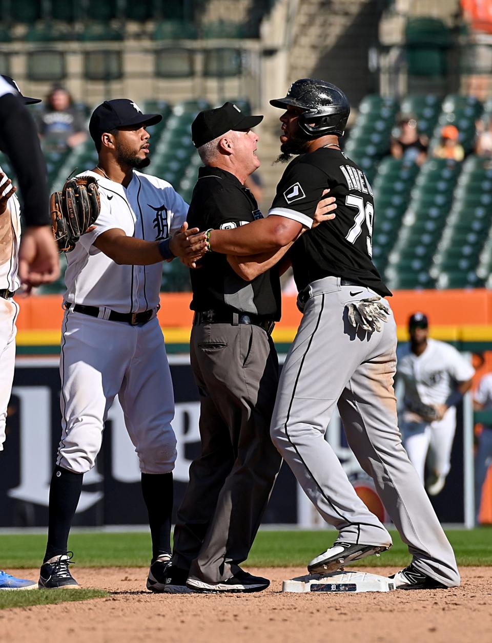 Tigers infielder Jeimer Candelario and an umpire try to calm White Sox baserunner Jose Abreu, after a ninth-inning play that caused a bench-clearing scrum during the Tigers' 8-7 loss Monday, Sept. 27, 2021, at Comerica Park.