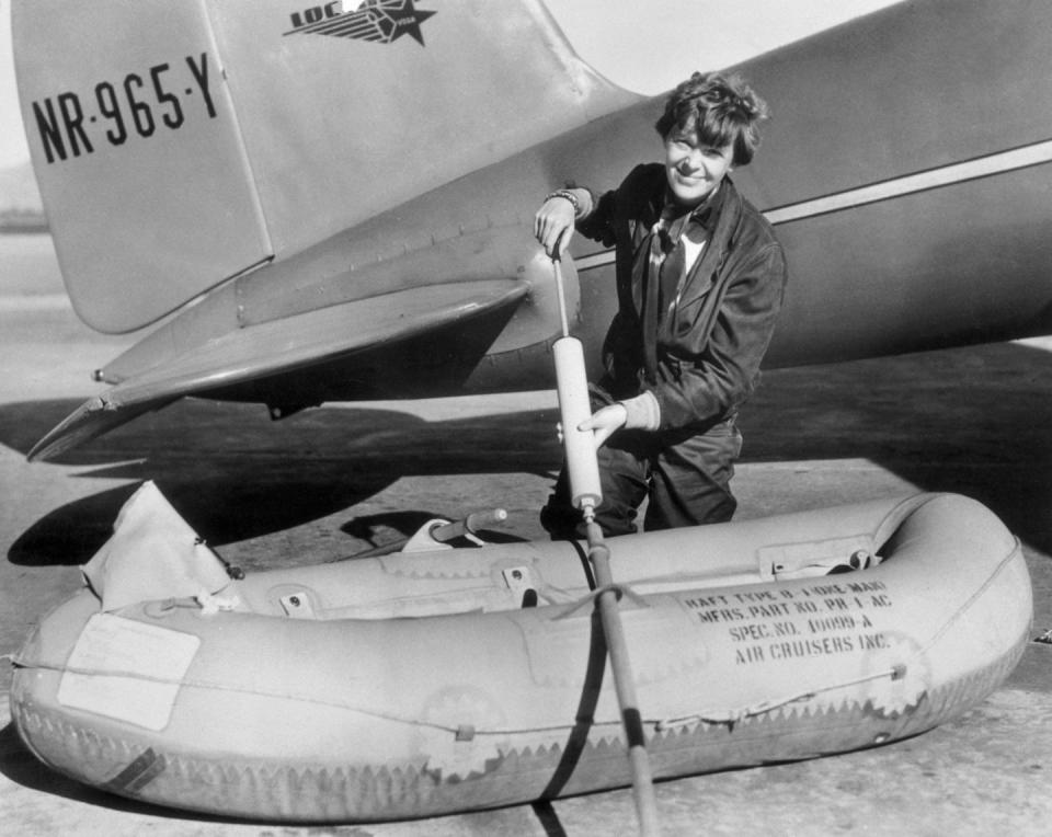 amelia earhart working on raft besides airplane