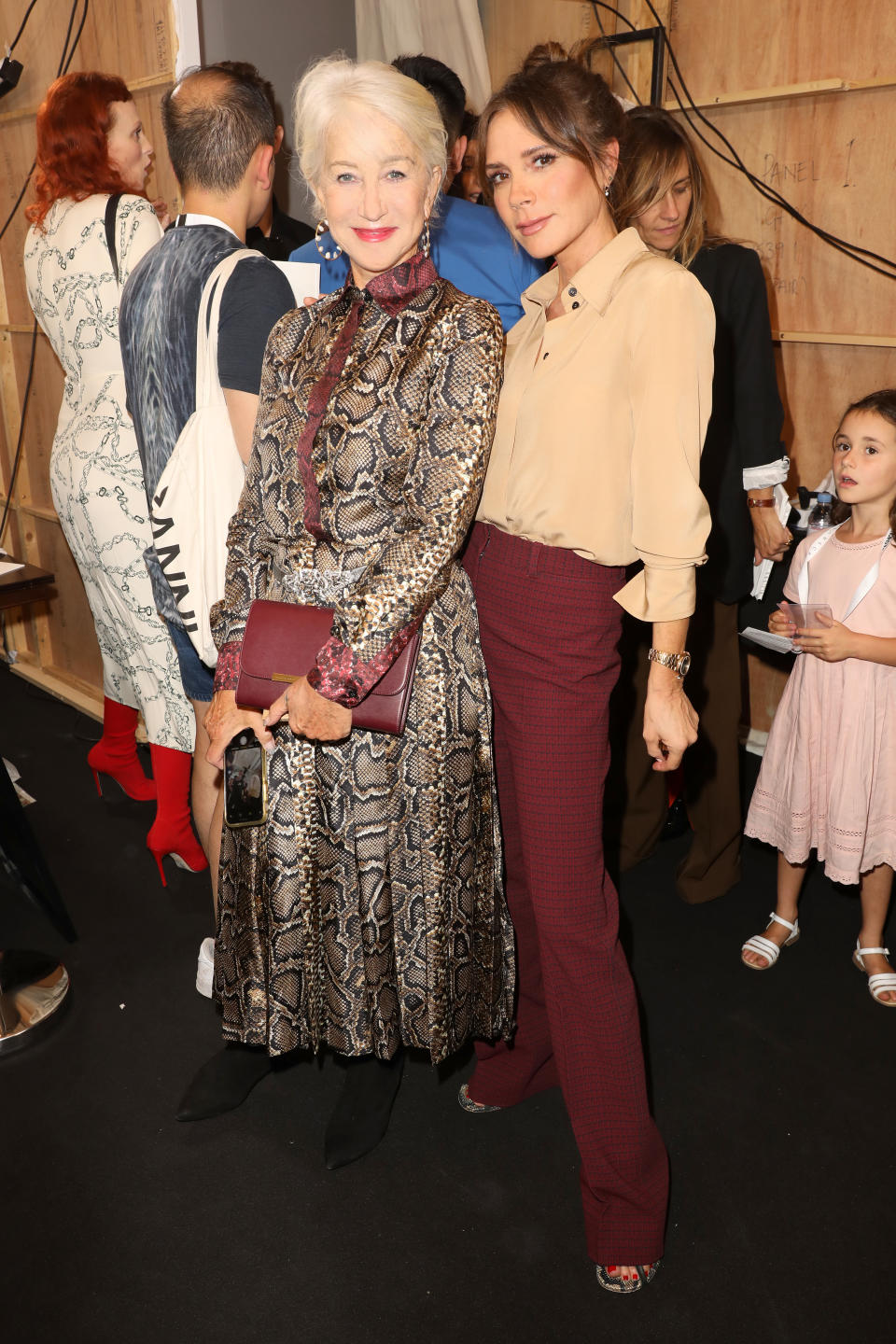 Helen Mirren and Victoria Beckham pose backstage [Photo: Getty]