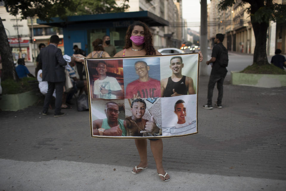 In this June 11, 2020 photo, Bruna Mozer holds a banner with photos of police violence victims, including her son Marcos, bottom center, during a protest against racism and police violence in Niteroi, Brazil. Mozer claims her son surrendered when police found him with a walkie-talkie in 2018 working for a gang, and then they executed him. (AP Photo/Silvia Izquierdo)