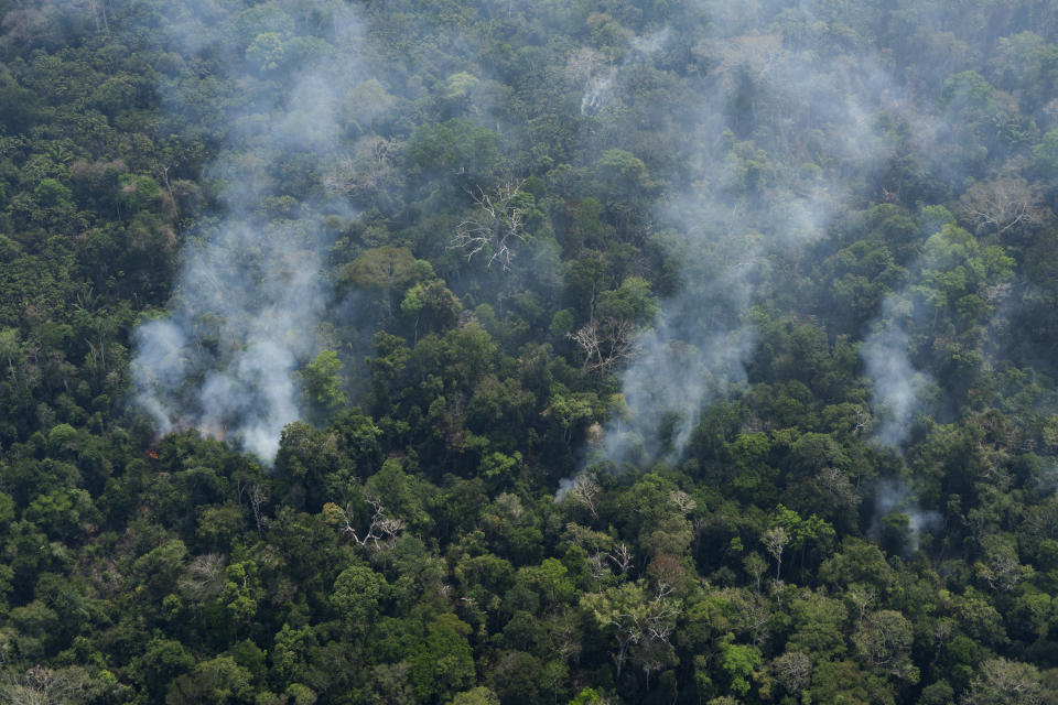 Small columns of smoke rise from the forest near Porto Velho, Brazil, Friday, Aug. 23, 2019. Under increasing international pressure to contain fires sweeping parts of the Amazon, Brazilian President Jair Bolsonaro on Friday authorized use of the military to battle the massive blazes. (AP Photo/Victor R. Caivano)