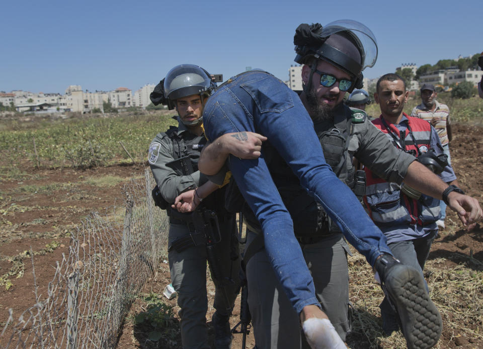 Israeli border police arrest an unconscious protester during a rally supporting Palestinian prisoners in Israeli jails, outside Ofer military prison, near the West Bank city of Ramallah, Thursday, Aug. 22. 2019. Israeli border police said the man was conscious when he was arrested. (AP Photo/Nasser Nasser)