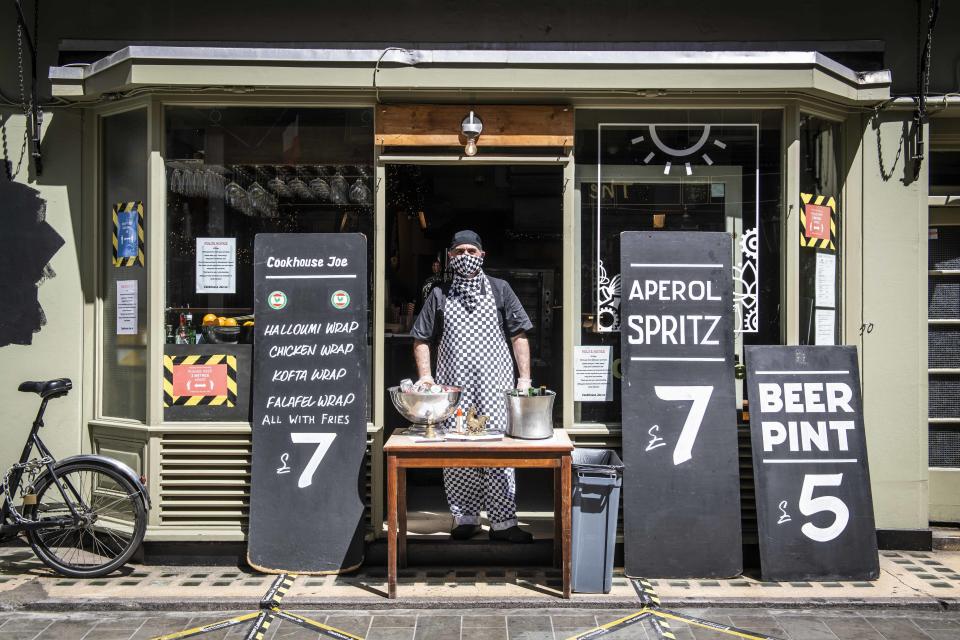 Cookhouse Joe's Chef awaits customers in the doorway of  the restaurant as it reopens to the public for takeaway only as the Coronavirus lockdown eases, Berwick Street, London. Picture date: Friday 29th May 2020. Photo credit should read: David Jensen/EMPICS Entertainment