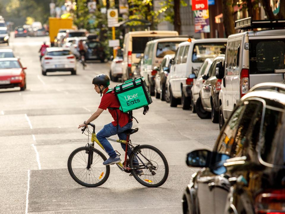 02 September 2021, Berlin: Silvan, a driver for food delivery service Uber Eats, rides a bicycle with a transport box on his back on a street in the Friedrichshain district of Berlin