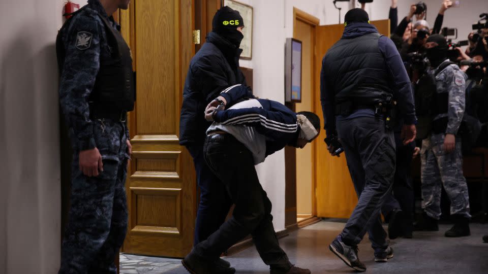 A man suspected of taking part in the attack is escorted by Russian law enforcement officers prior to his pre-trial detention hearing at the Basmanny District Court in Moscow on March 24, 2024. - Tatyana Makeyeva/AFP/Getty Images