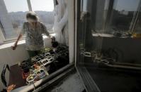 Pensioner Lyudmila Kholeva demonstrates how she tends to vegetable sprouts and seeds at the balcony of her apartment in Moscow, Russia, April 12, 2016. REUTERS/Maxim Shemetov