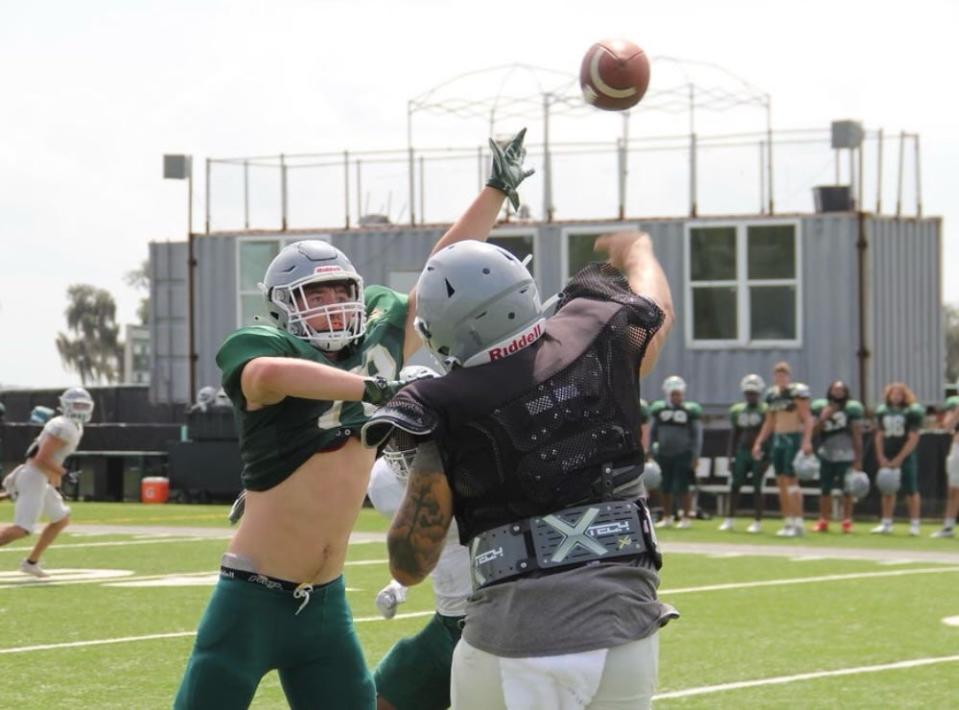 First-year Webber linebacker Mitchell Cain attempts to deflect a pass in practice.