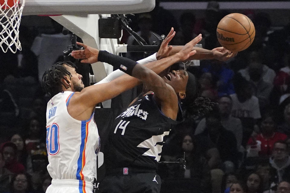 Oklahoma City Thunder center Olivier Sarrp, left, blocks the shot of LA Clippers guard Terance Mann during the first half of an NBA basketball game Thursday, March 23, 2023, in Los Angeles. (AP Photo/Mark J. Terrill)