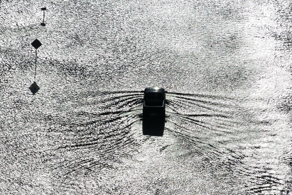 A truck navigates through floodwaters in a residential neighborhood west of Houston.