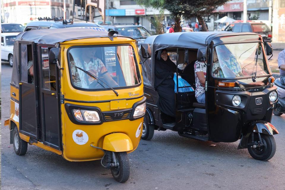 tuktuk taxis drive on a street in the northern lebanese city of tripoli