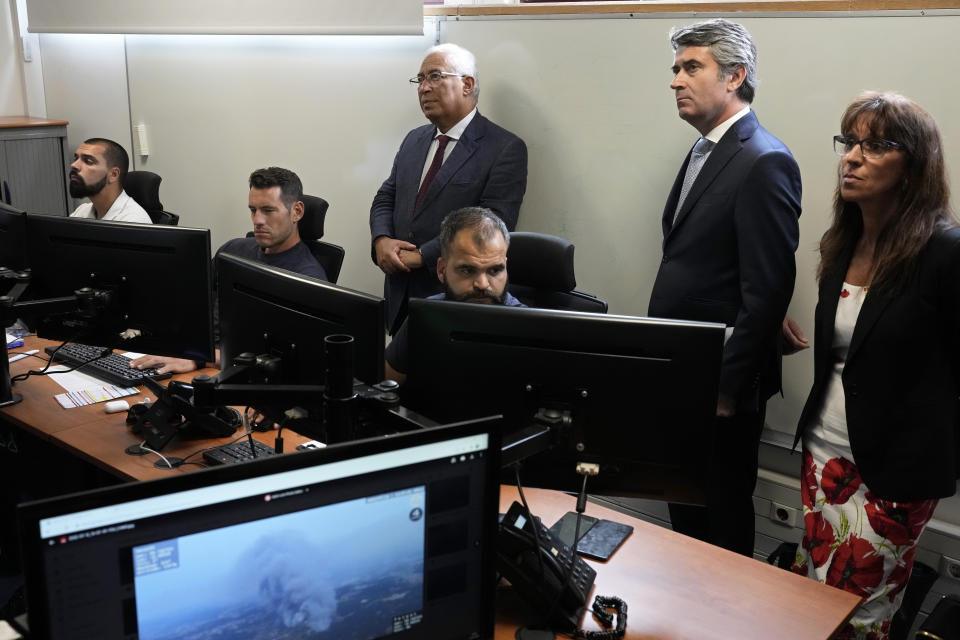 Portuguese Prime Minister António Costa, background left, visits a room dedicated to the monitoring of forest fires, at the Civil Protection Agency headquarters in Oeiras, outside of Lisbon, Tuesday, July 12, 2022. Portugal is experiencing a heatwave that led the government to declare a state of alert from Monday through Friday due to the heightened risk of forest fires. Temperatures are forecast to reach 46 degrees Celsius (115 Fahrenheit) in some parts of the country by Wednesday. (AP Photo/Armando Franca)