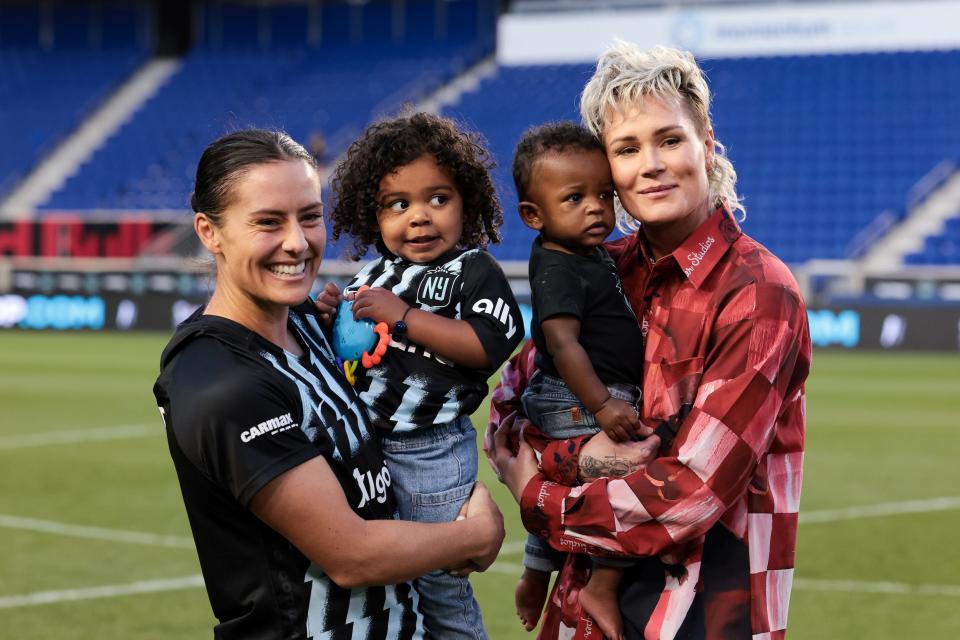 Ashlyn Harris (right) holds son Ocean as she poses for a photo with then-wife Ali Krieger (left) and daughter Sloane.