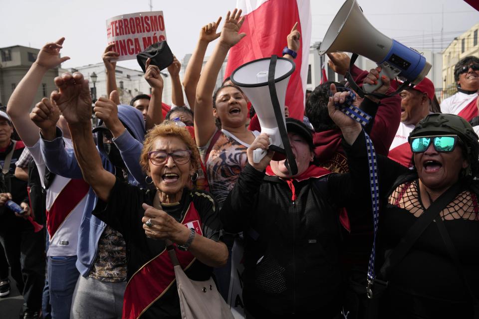 Opponents of Peruvian President Pedro Castillo rally near the police station, where he arrived and his status was not immediately clear, in Lima, Peru, Wednesday, Dec. 7, 2022. Peru’s Congress removed Castillo from office Wednesday, voting to replace him with the vice president, shortly after Castillo decreed the dissolution of the legislature ahead of a scheduled vote to oust him. (AP Photo/Martin Mejia)