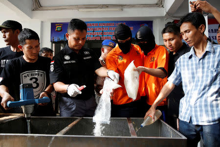 Recently arrested drug trafficking suspects are forced to take part in the destruction of illegal narcotics at police headquarters in Jakarta, Indonesia July 21, 2016. Picture taken July 21, 2016. REUTERS/Darren Whiteside