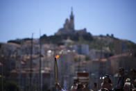The Olympic torch is raised during the torch relay in Marseille, southern France, Thursday, May 9, 2024. Torchbearers are to carry the Olympic flame through the streets of France' s southern port city of Marseille, one day after it arrived on a majestic three-mast ship for the welcoming ceremony. (AP Photo/Daniel Cole)