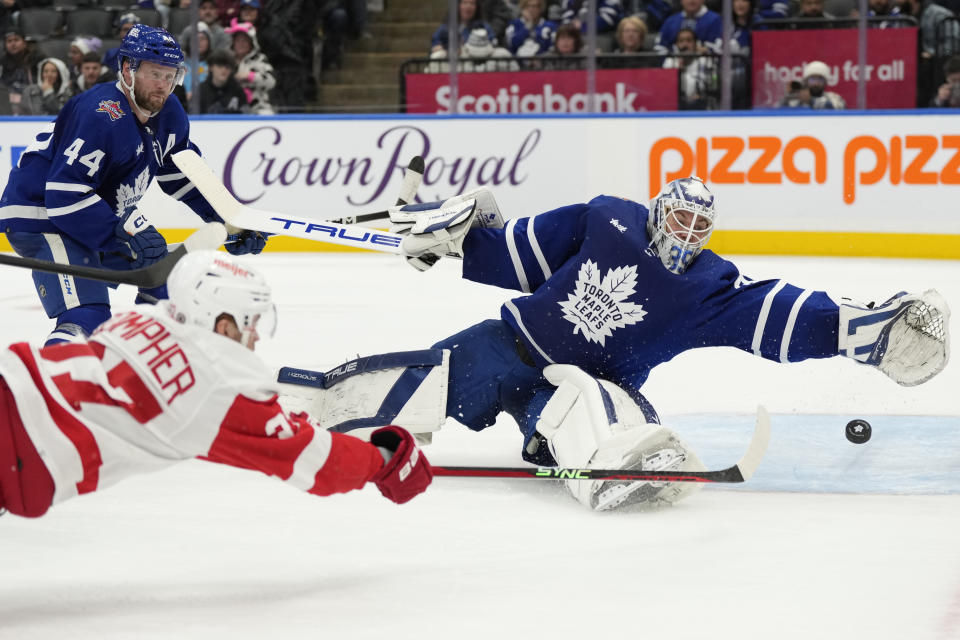 Toronto Maple Leafs goalie Ilya Samsonov, right, makes save against Detroit Red Wings J.T. Compher, bottom left, during third-period NHL hockey game action in Toronto, Sunday, Jan. 14, 2024. (Frank Gunn/The Canadian Press via AP)