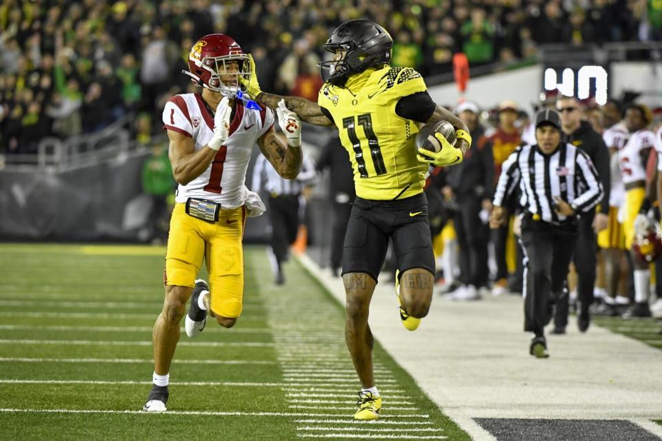 Oregon wide receiver Troy Franklin tries to escape the grasp of USC cornerback Domani Jackson along the sideline.