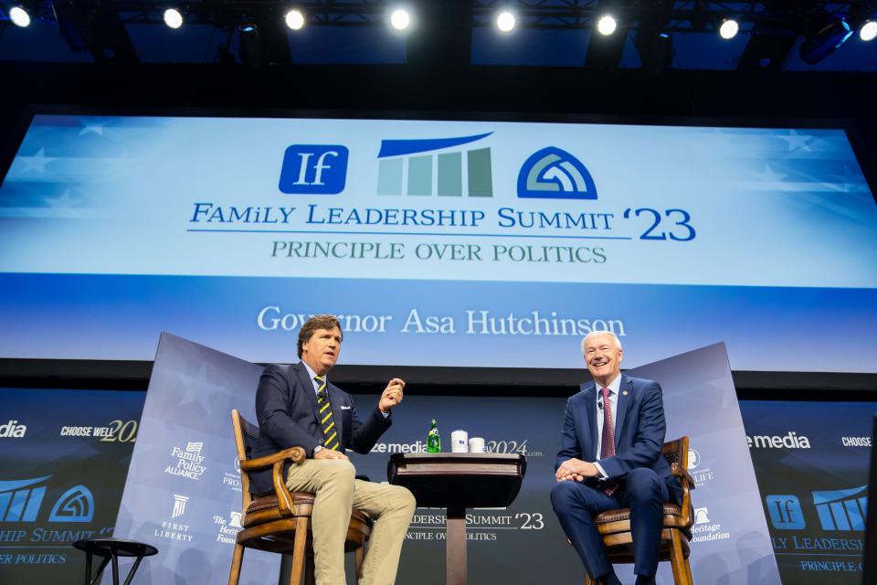 Republican presidential candidate former Arkansas Gov. Asa Hutchinson talks with moderator Tucker Carlson, left, during the Family Leadership Summit in Des Moines, Friday, July 14, 2023. 