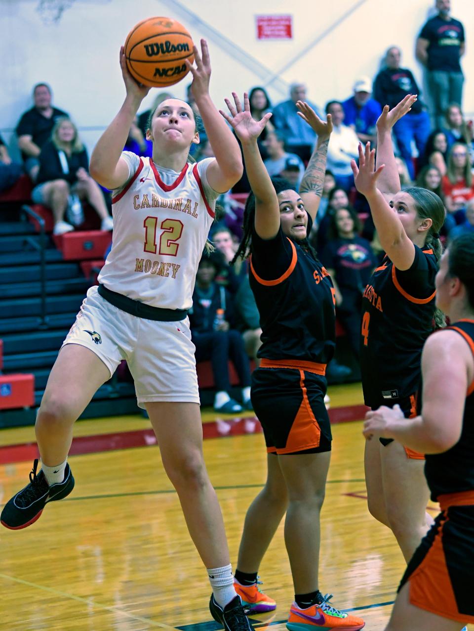 Cardinal Mooney Catholic's Madi Mignery (12) a small forward (SF) and guard (G) scores an easy two points during the 2nd period of play against the Sarasota Sailors Friday night at Mooney's at JM Patterson Pavilion in Sarasota.