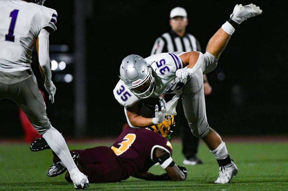 Bloomington South’s Gavin Adams (35) is tackled by Bloomington North’s Stephon Opoku (3) during the IHSAA sectional semi-final football game at Bloomington North on Friday, Oct. 27, 2023.