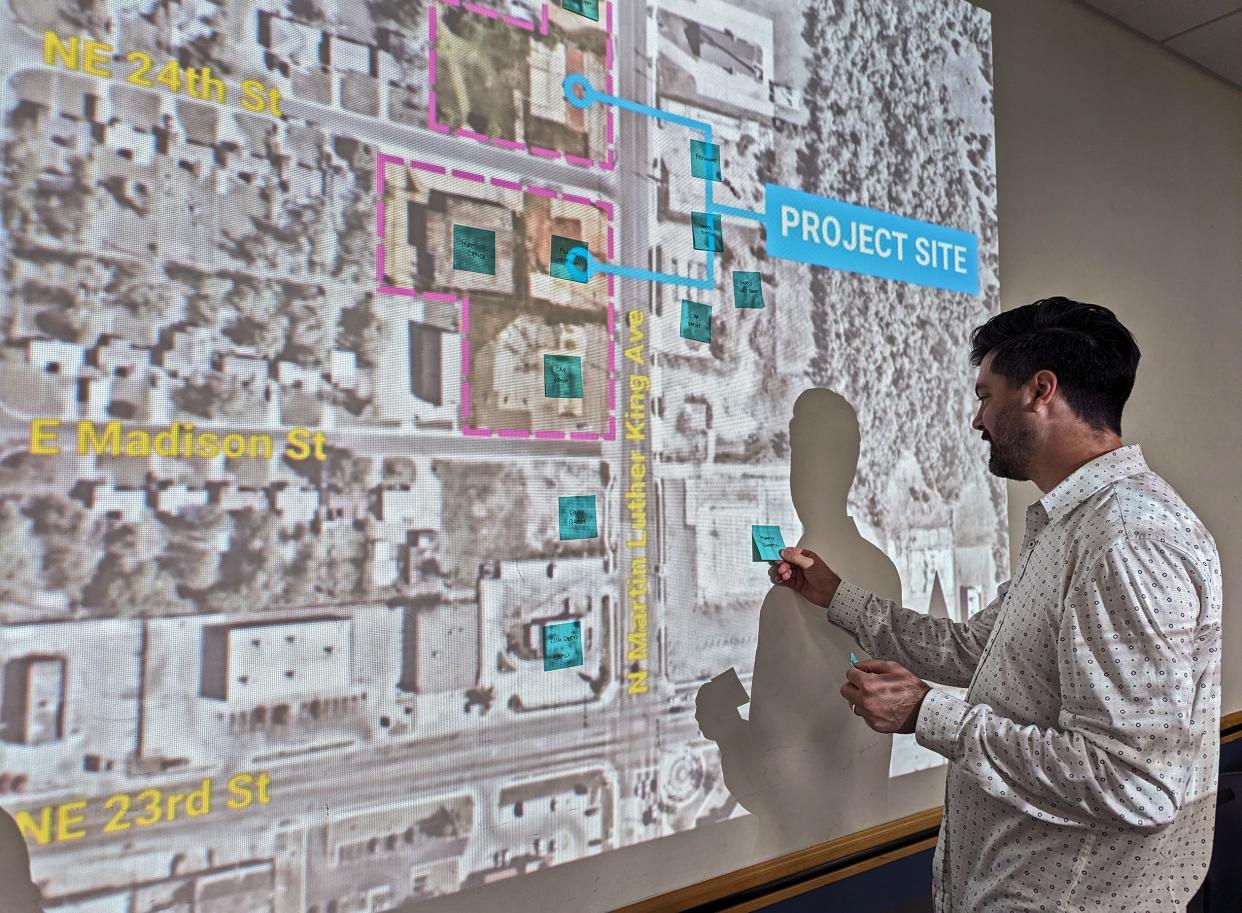 Collin Fleck, an architect with Bockus Payne, gathers notes left by residents on the project site map for the upcoming Clara Luper Civil Rights Center during a listening session at the Ralph Ellison Library in northeast Oklahoma City.